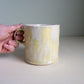 runny pastel yellow checkered mug